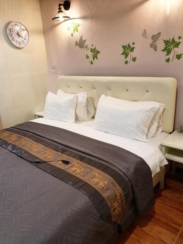 a bedroom with a large bed with a clock on the wall at Cana Boutique Hotel in Bangkok