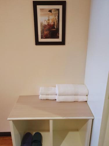 a table with two towels and a picture on the wall at Cana Boutique Hotel in Bangkok