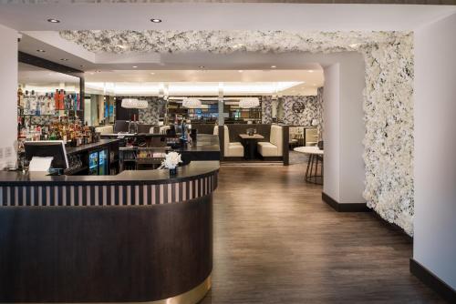 a lobby with a bar and a restaurant at Dalmeny Park House Hotel in Barrhead