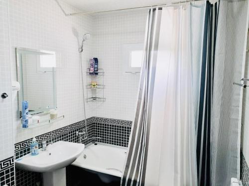 y baño blanco con lavabo y ducha. en Samarkand Apartment, en Samarkand