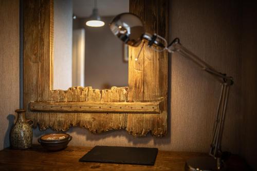 a desk with a lamp and a mirror on a wall at Quayside Apartment in Portree
