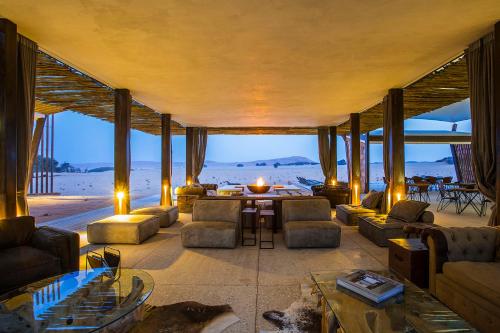 a living room with couches and a table and the beach at Dead Valley Lodge in Sesriem