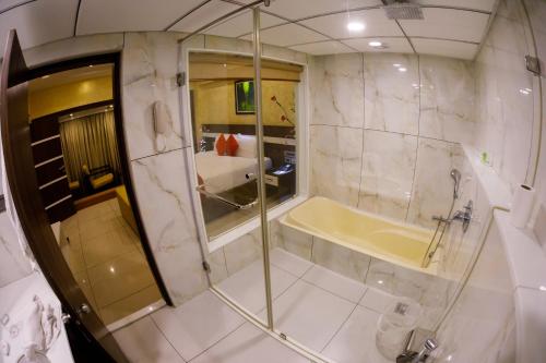 a bathroom with a shower and a bath tub at The Renai Cochin in Cochin