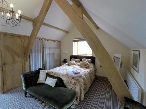 a bedroom with a bed and a chair at Broome Farm in Ross on Wye