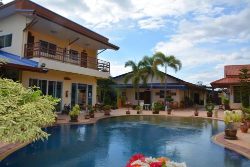 uma piscina em frente a uma casa em Baan Sabaijai Resort & Omsorgssenter em That Phanom