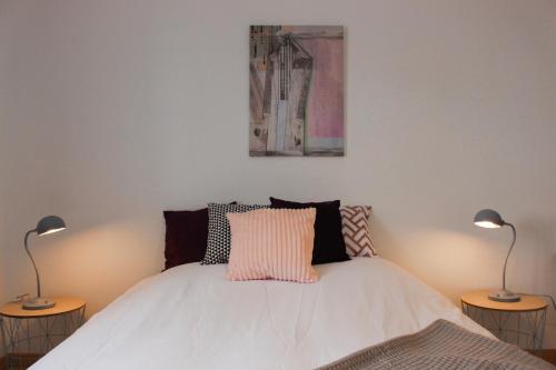 1 dormitorio con 1 cama blanca y 2 lámparas en HAPPY MAMA COLMAR with PARKING en Colmar