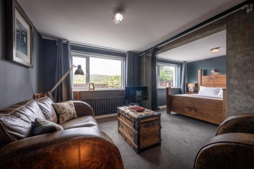 1 dormitorio con cama, sofá y TV en Storr Apartments, en Portree