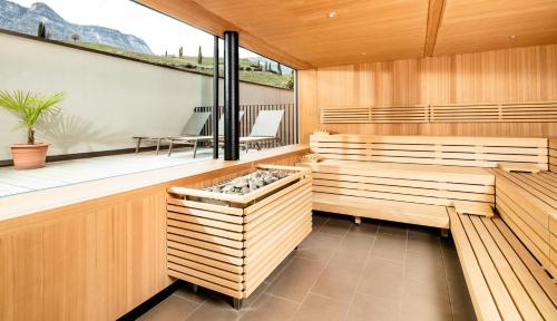 a sauna with wooden benches and a window at Hotel Thalhof am See in Caldaro