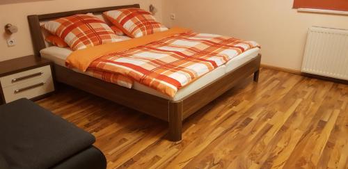 a bed with an orange and white comforter in a bedroom at Ferienwohnung Silvia in Sankt Kanzian