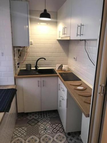 a small kitchen with white cabinets and a sink at STUDIO RICHARD in Braşov