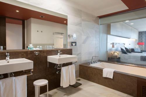 a bathroom with two sinks and a large mirror at Hipotels Gran Conil & Spa in Conil de la Frontera