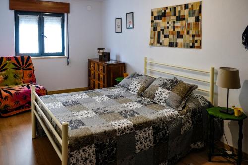 a bedroom with a bed with a quilt on it at Casa do Ferreiro II in Góis