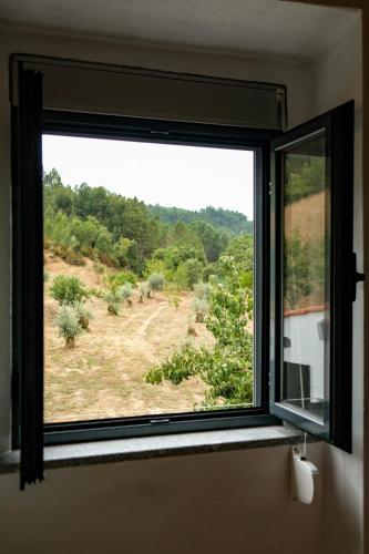 a window in a room with a view of a field at Casa do Ferreiro II in Góis