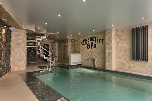 a large swimming pool in a building with a swimming pool at Chevalier Hotel & SPA in Bukovel