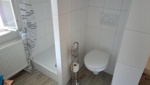 uma casa de banho branca com um WC e um chuveiro em Erholung im Grünen em Hemmingen