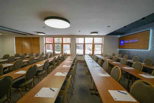 an empty classroom with long tables and chairs at Grand Hotel BELLEVUE in Smokovce
