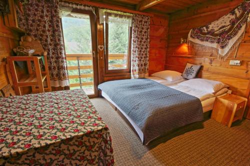 a bedroom with a bed and a window in a cabin at Willa Długoszówka in Zakopane