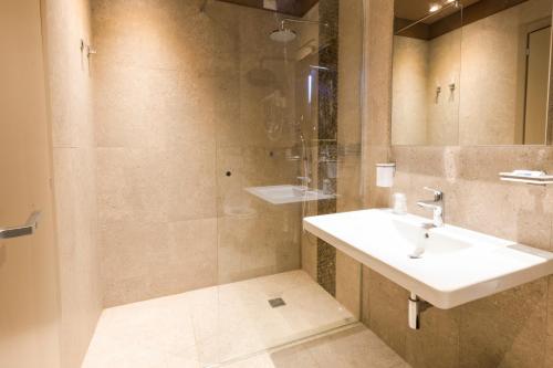 y baño con lavabo y ducha. en Hotel Residence Sciaron, en Capo Vaticano