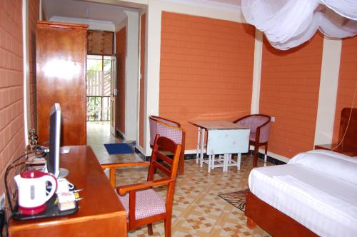a bedroom with a bed and a desk and a table at Kakakuona Resort in Lushoto