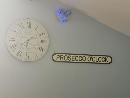 a clock on a wall with a sign on it at Couples Country Escape includes Private Indoor Pool and Hot tub in North Wales in Bagilt