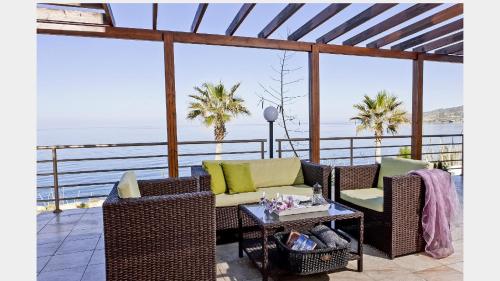 a patio with chairs and a table with a view of the ocean at Kallinousa Beach Villa in Pomos