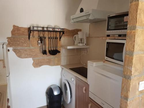 a kitchen with a washing machine and a microwave at L Appicciu in Ventiseri