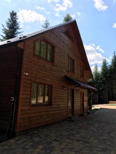 a large wooden building with windows on the side of it at Ялинка in Migovo