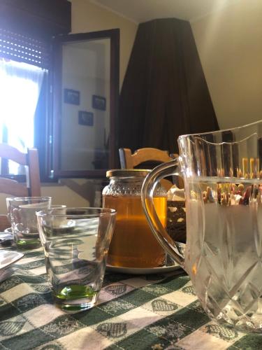 - une table avec un pot de miel et des verres dans l'établissement Domus Birdi, à Orroli