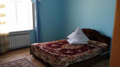 a blue room with a bed with a pillow on it at Apartments on Балауса, 2 in Aktau