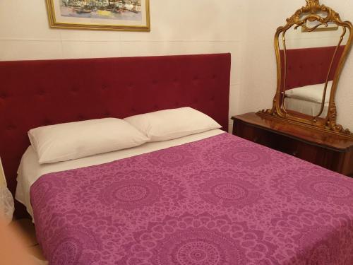 a bed with a purple blanket and a mirror at Apartment Astra in Rijeka