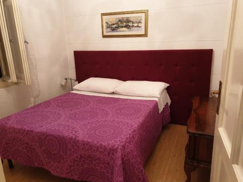 um quarto com uma cama roxa com um cobertor roxo em Apartment Astra em Rijeka