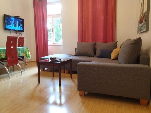 uma sala de estar com um sofá e uma mesa em Apartment Astra em Rijeka