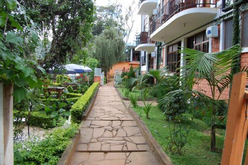 a walkway in a garden next to a building at Kakakuona Resort in Lushoto