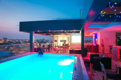 a swimming pool with a person in the middle of a building at Suncity Hotel Apartment in Accra