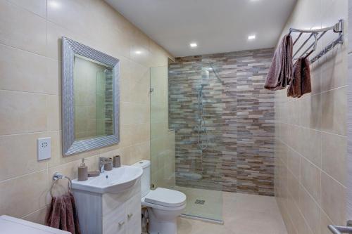 e bagno con doccia, servizi igienici e lavandino. di Harmony Apartments a Msida