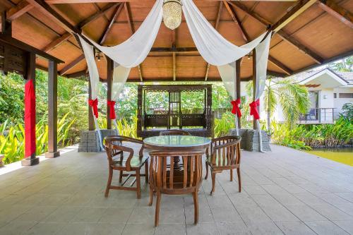 een patio met een tafel en stoelen en een tent bij Sheridan Boutique Resort Iloilo in Iloilo City