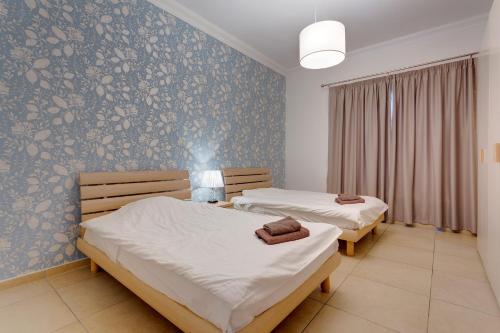 2 camas en un dormitorio con un mural en la pared en Apartment In Fort Cambridge with Pool, en Sliema