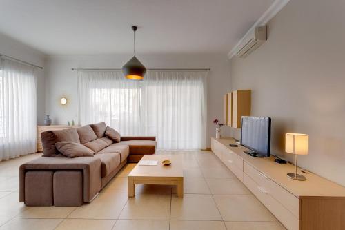 a living room with a couch and a tv at Apartment In Fort Cambridge with Pool in Sliema
