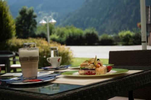 a table with a plate of food and a glass of milk at Hotel Flattacher Hof in Flattach