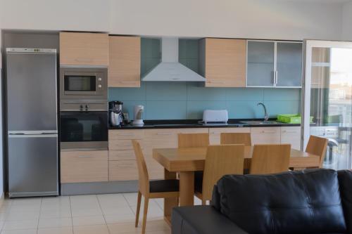 a kitchen with a wooden table and a dining room at Agua Hotels Sal Vila Verde in Santa Maria