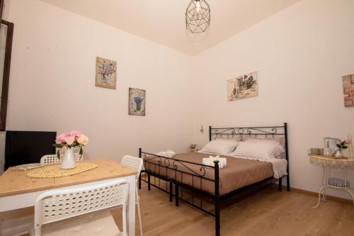 a bedroom with a bed and a table at La Casa del Gelsomino in Tivoli