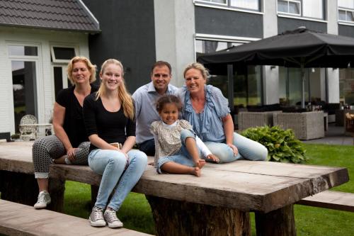 a group of people sitting on a wooden bench at De Slaapfabriek vakantiehuis en trainingslocatie in Teuge
