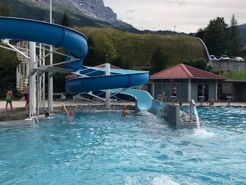 a group of people in a swimming pool with a water slide at Chalet zur Höhe in Grindelwald