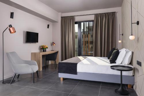 1 dormitorio con 1 cama, 1 mesa y 1 silla en Azur Suites, en Atenas