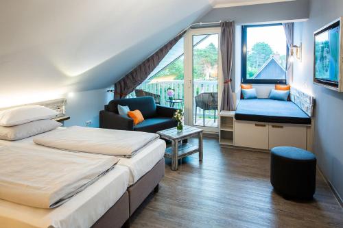 a hotel room with two beds and a balcony at Bude54 in Sankt Peter-Ording