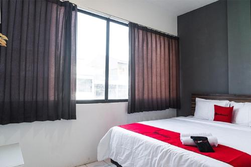 ein Schlafzimmer mit einem großen Bett mit einer roten Decke in der Unterkunft RedDoorz near Seasons City Mall in Jakarta