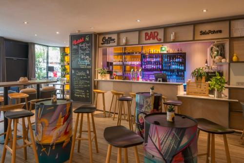 a bar in a restaurant with stools and a counter at Novotel Marseille Centre Prado Vélodrome in Marseille