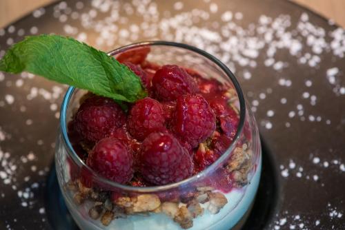 a glass jar of raspberries with a green leaf on top at Novotel Marseille Centre Prado Vélodrome in Marseille