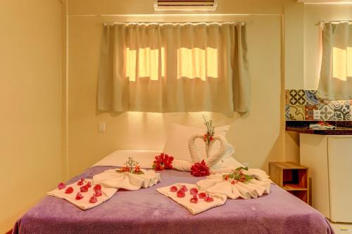 a bed with towels and flowers on top of it at i9 Quixaba Flat in Itacaré