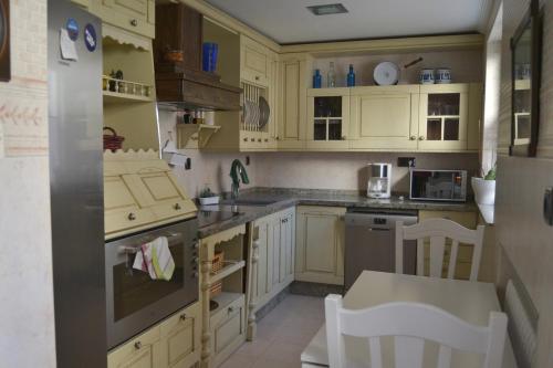 a kitchen with yellow cabinets and a stove top oven at MENCIA in Mansilla de las Mulas